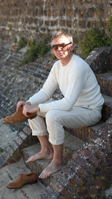 Cyril met ses chaussures Weston sur les marches des escaliers à Trouville et porte le pantalon Casimir en coton et cachemire beige clair de la Maison Gabriel Paris