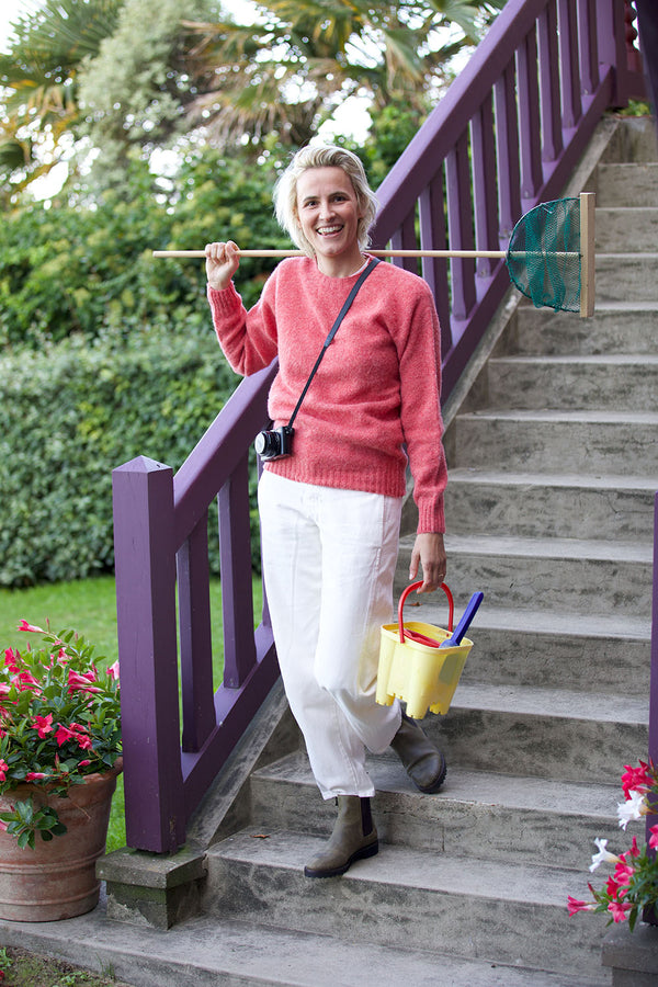 Fanny prend la pose à Trouville et porte le pull Victor en shetland col rond coloris rose - collection Automne-Hiver 2024 - de la Maison Gabriel Paris