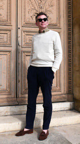 Cyril pose dans la cour du Louvre et porte le pull Aimé en baby cachemire blanc cassé de la Maison Gabriel Paris