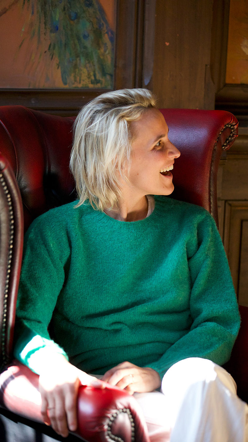 Fanny prend la pose à Trouville et porte le pull Victor en shetland col rond coloris vert émeraude - collection Automne-Hiver 2024 - de la Maison Gabriel Paris